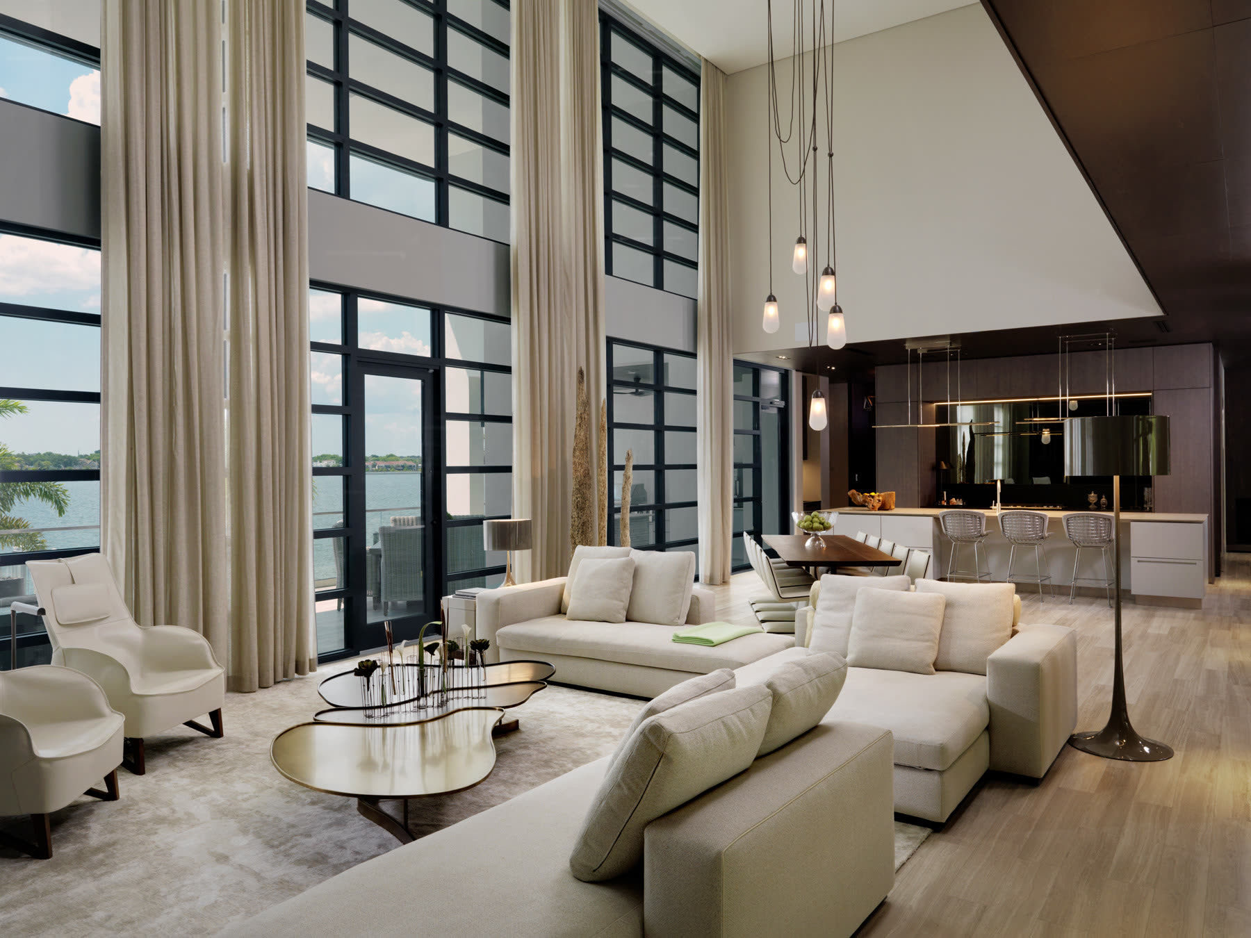 Living, dining and kitchen, shades down. Residence by M2Develop